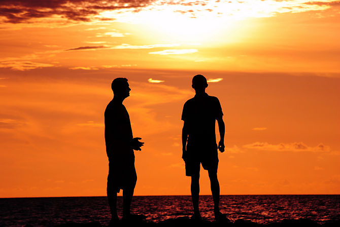 Image de deux hommes discutant lors d'un coucher de soleil