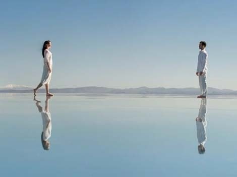 Image d'une femme et un homme ainsi que leur reflet dans l'eau