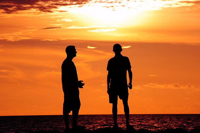 Deux hommes discutant lors d'un coucher de soleil